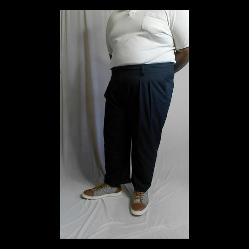 Person wearing navy Super 140 Merino Wool pants and a white shirt against a plain background