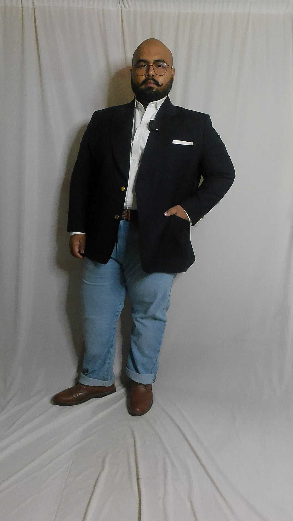 Person on a white floor with a Super 140 Navy Blazer and blue jeans.