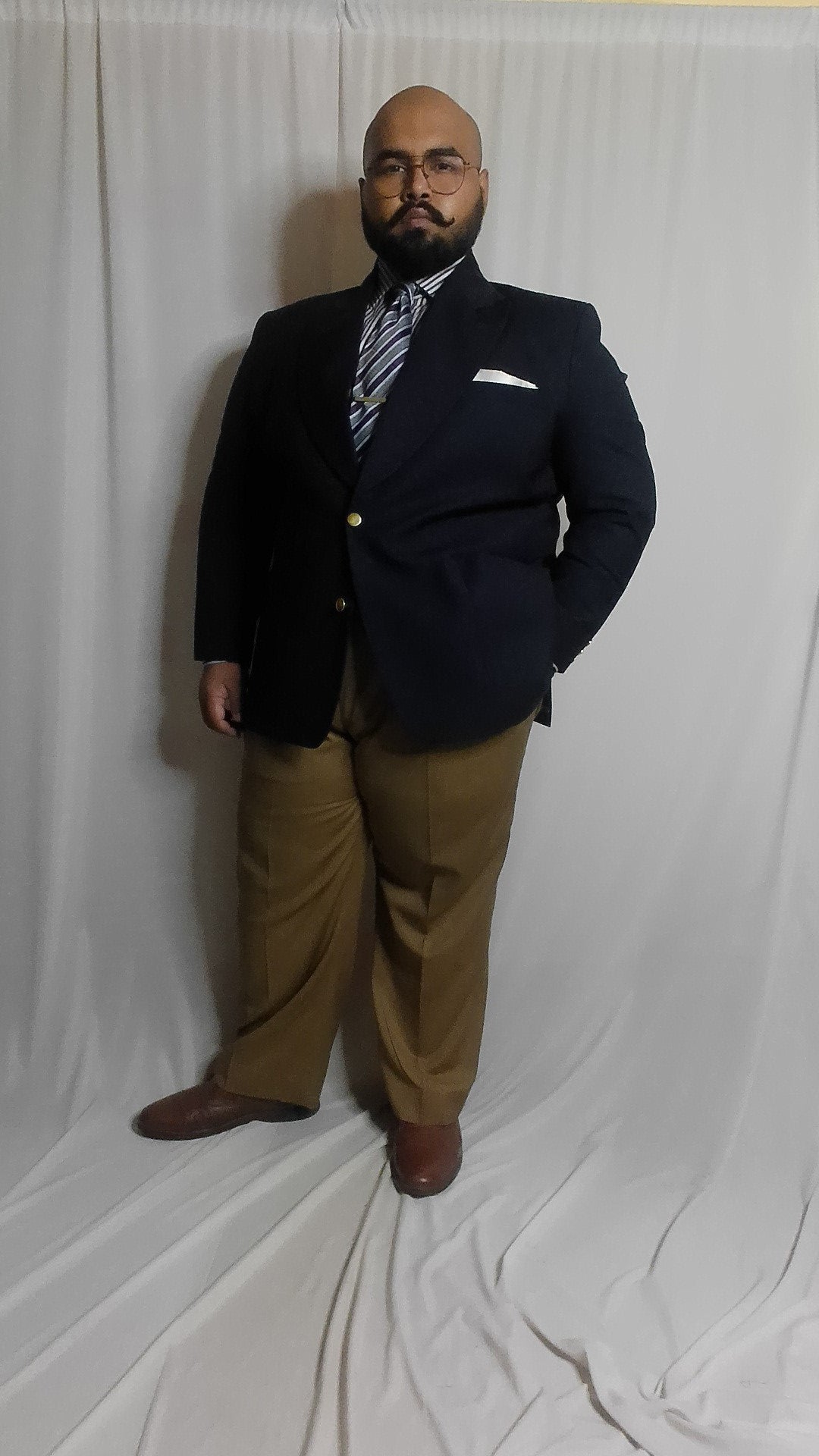 Man wearing a dark navy blazer and khaki pants.